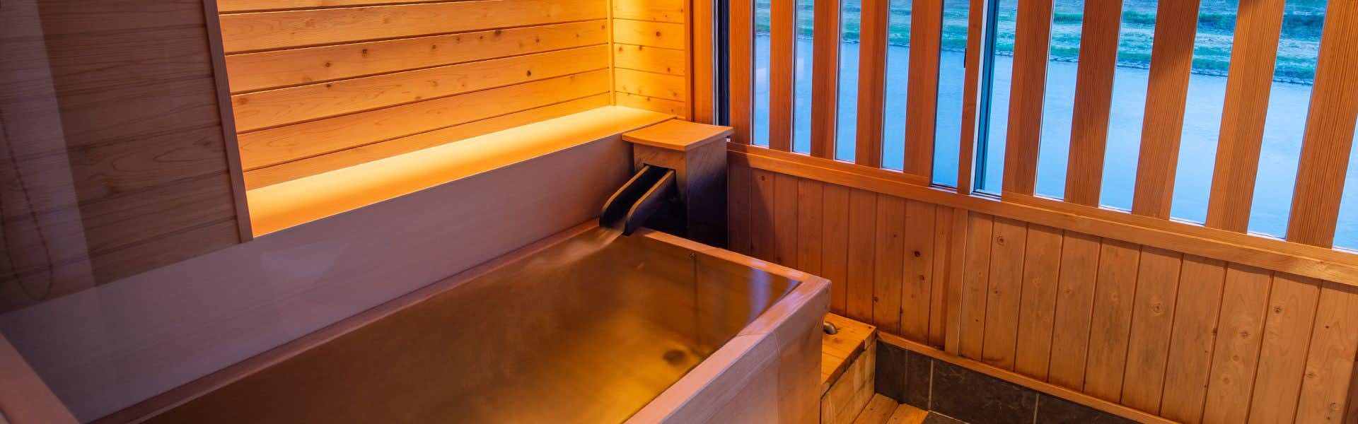 Harazuru Onsen Harazuru no Mai rectangular wood-lined bath beside a riverside window