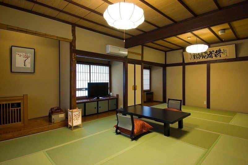 Yoshinari Inn with a calm tatami guest room centered on a low black table.