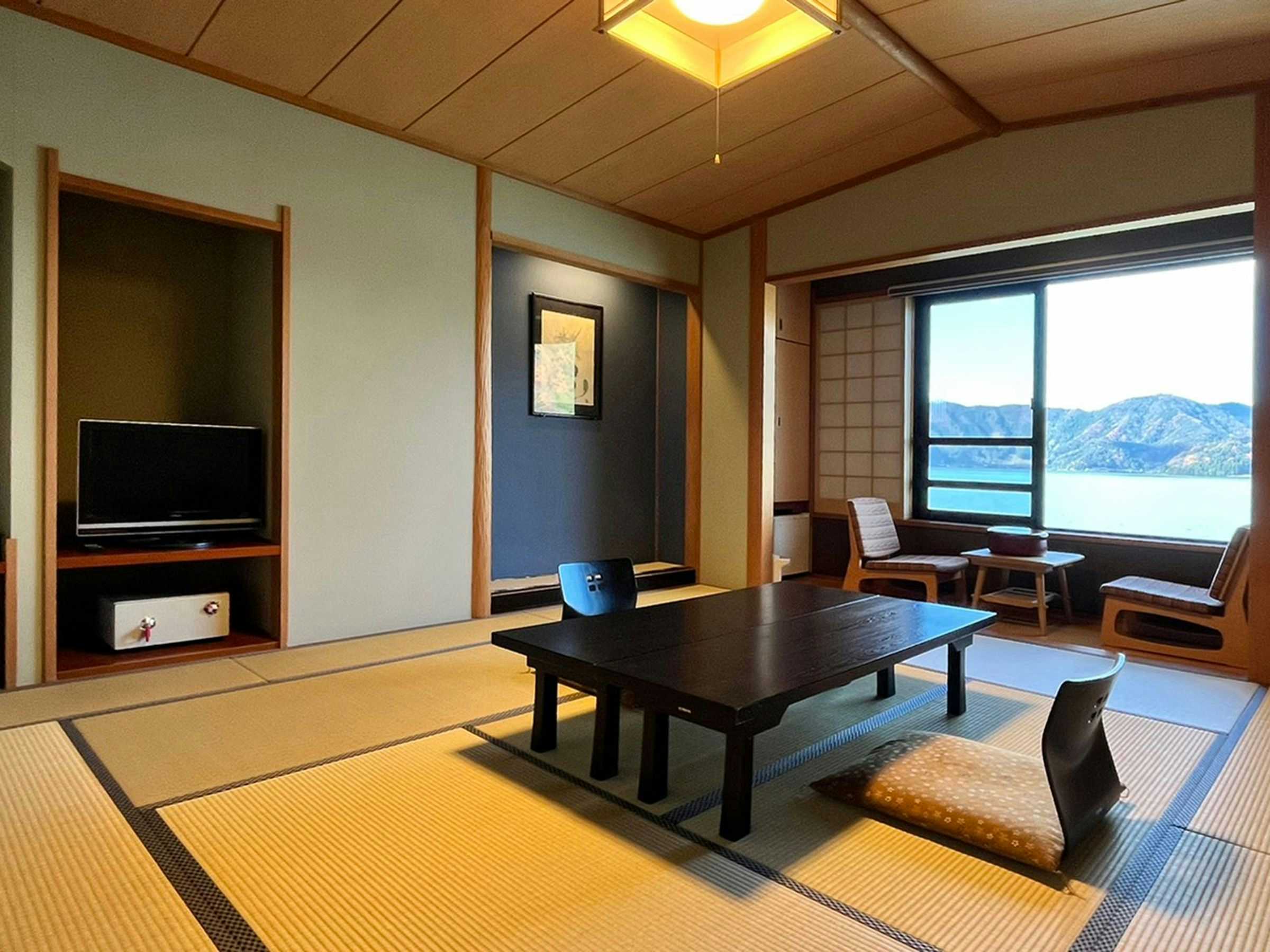 Natural Onsen Okasanya Irokasane with a tatami room overlooking blue lake and mountains.