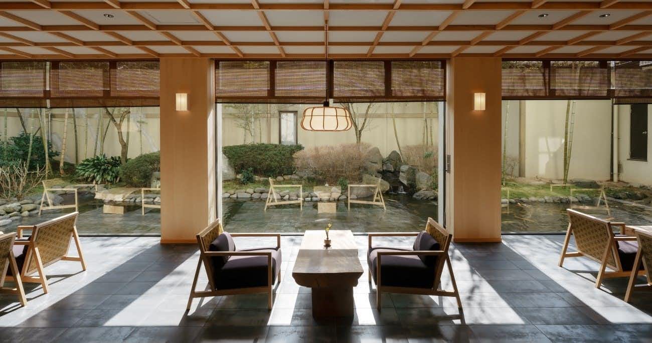 Kakurega Yukari with a garden-facing lounge with armchairs beneath a timber lattice ceiling.