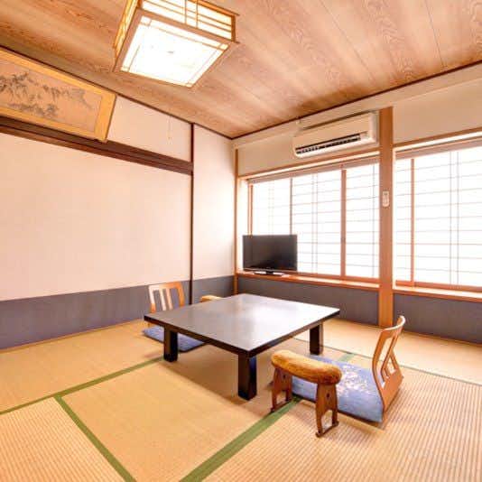 Shiratame Ryokan: A simple tatami room with low table and broad windows.