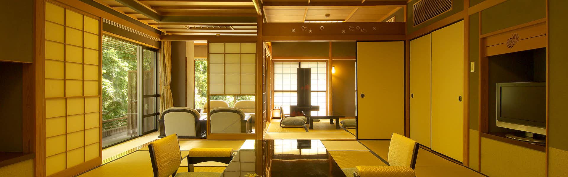 Kawaizuen Isuzu Hotel with a bright tatami room with armchairs beside a garden window.