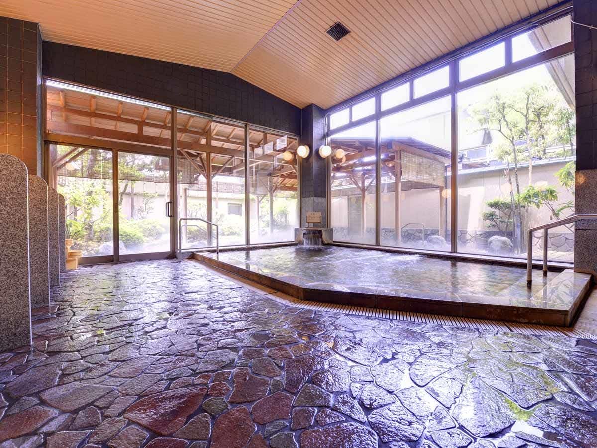 Keisenkaku with an indoor stone bath facing a bright garden courtyard.