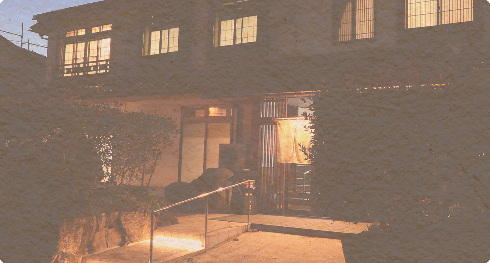 The ryokan entrance illuminated at dusk.