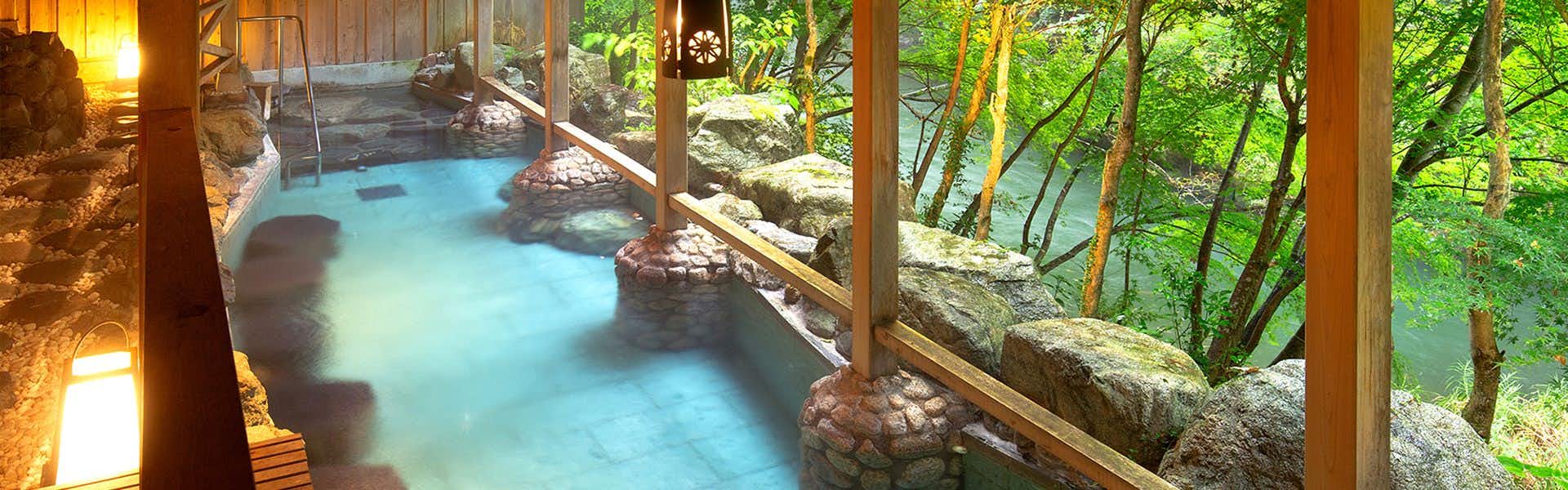Kagari Kisshotei with an open-air bath overlooking dense riverside forest.