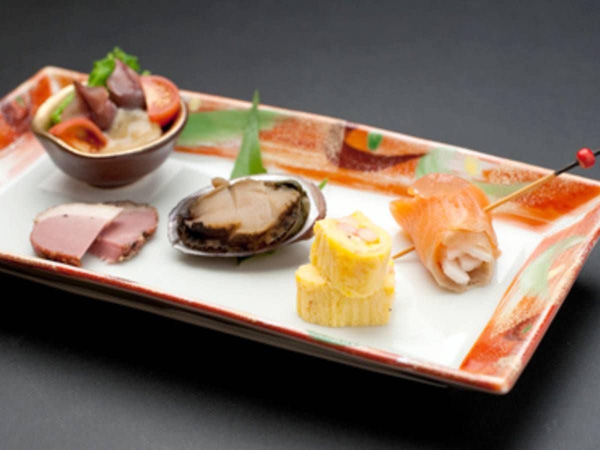 Nakanoya Ryokan with a seafood appetizer platter featuring shellfish and sliced fish.