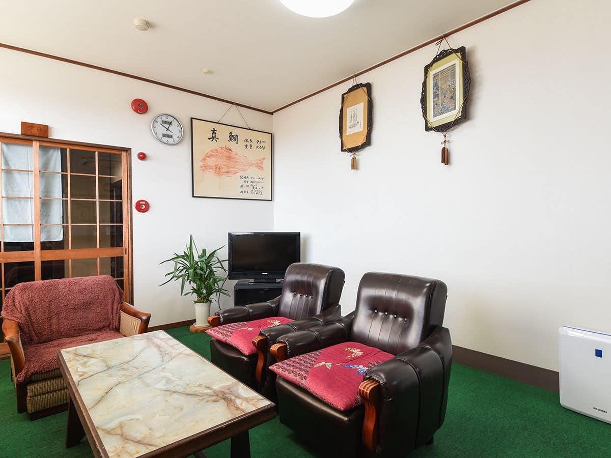 Ryokan Onishi with a simple lounge with red and black armchairs.