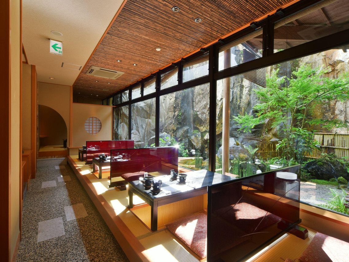 A glass-walled lounge looks into a landscaped garden.