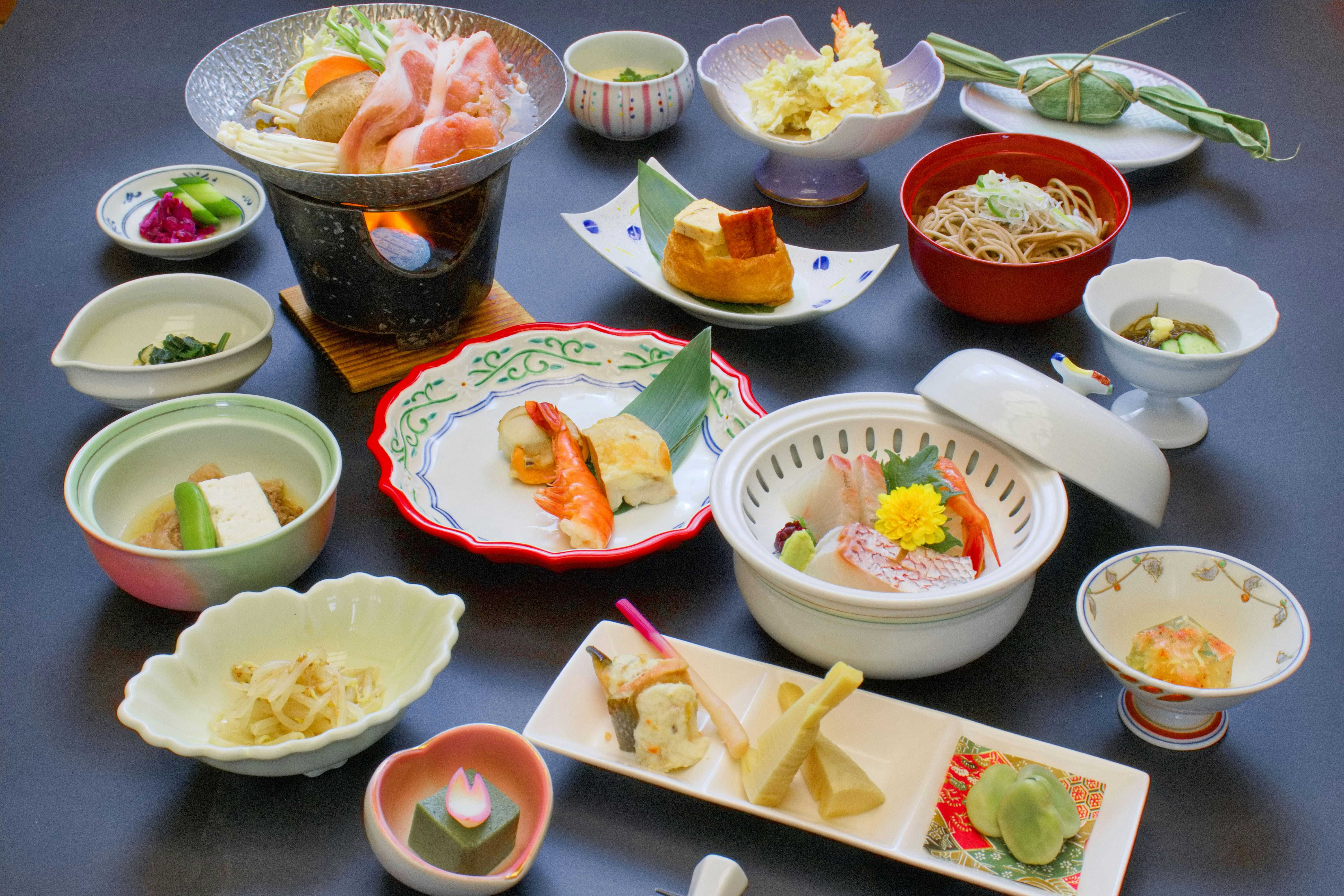 Sakihana Onsen Suigyoku no Yu Satorikan with a Japanese dinner arranged across many small ceramic dishes.