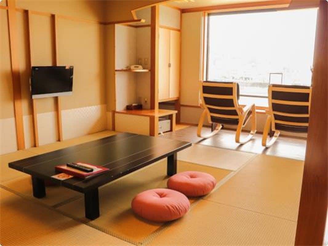 Ryotei Onsen Ryokan Shunjyuan Mizunowo with a bright tatami room with red cushions and window chairs.