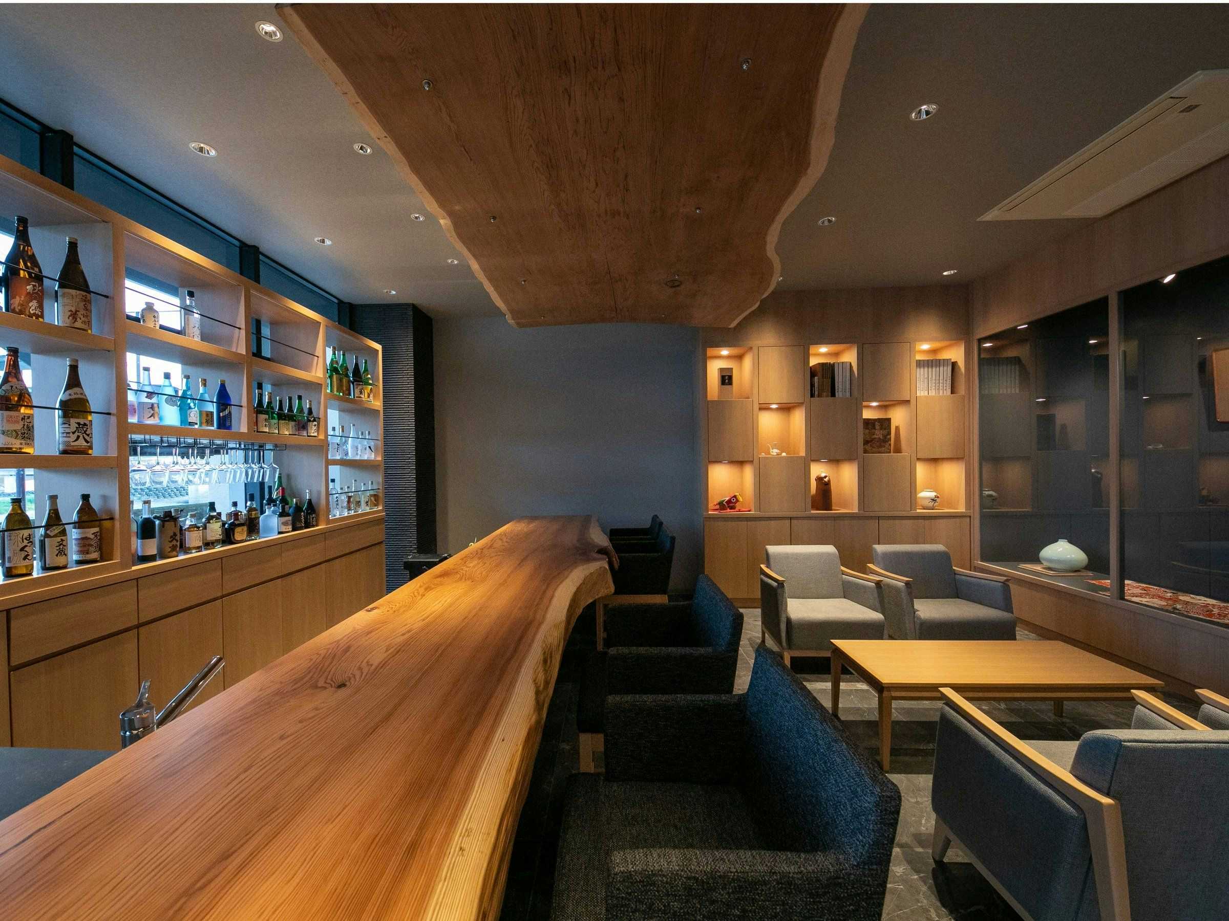 Hitoyoshi Onsen Nabeya (Formerly: Nabeya Main Building) with a polished timber bar lined with local bottles.