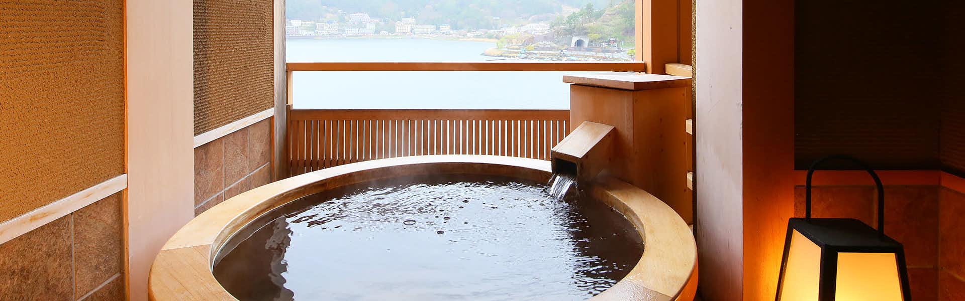 Hana Mizutei Ooya with a round private bath beside lake-facing windows.