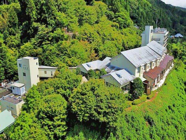 Takimien aerial view of the lodging exterior surrounded by dense trees
