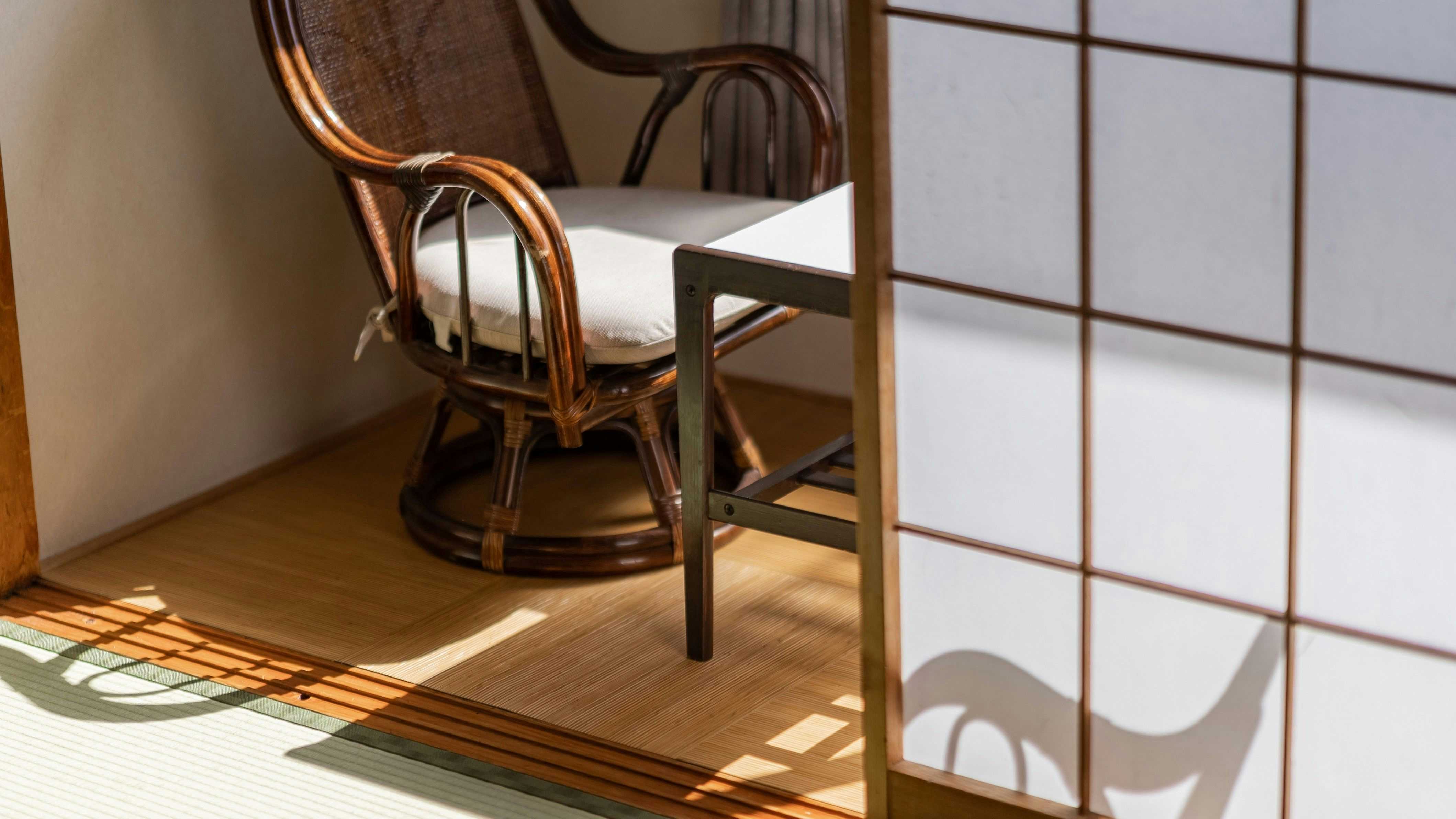 Hanayama Onsen Yakushi no Yu: A sunlit window alcove with wicker chair and mountain view.