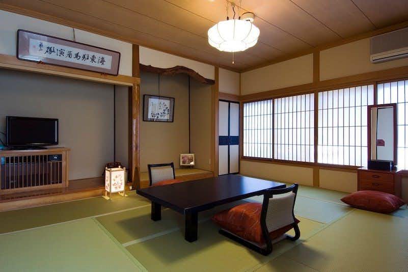 Yoshinari Inn with a broad tatami room with long table and window seating.