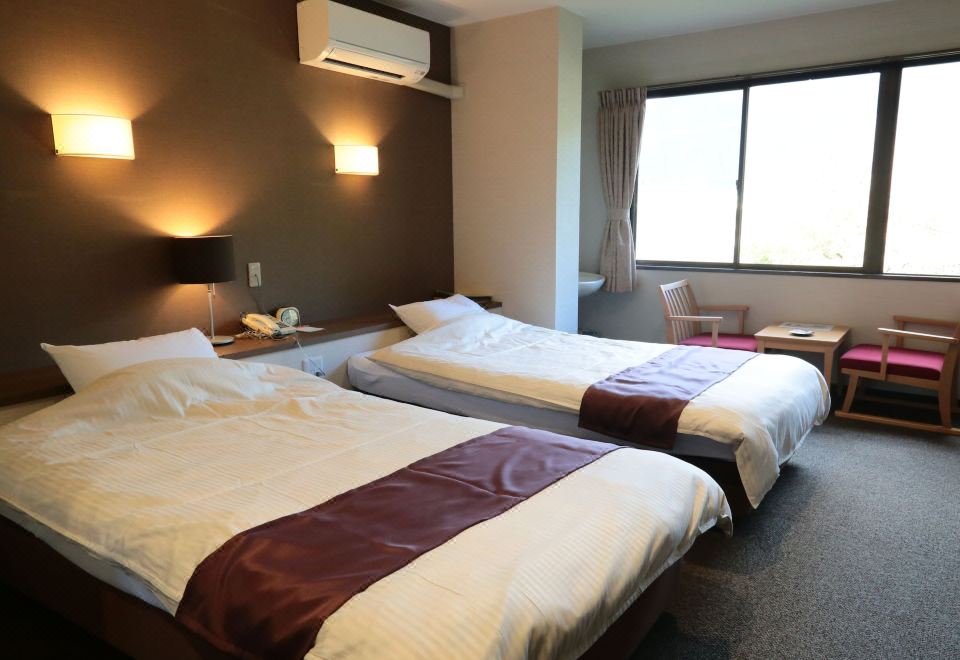 A twin room with two beds and low tables.