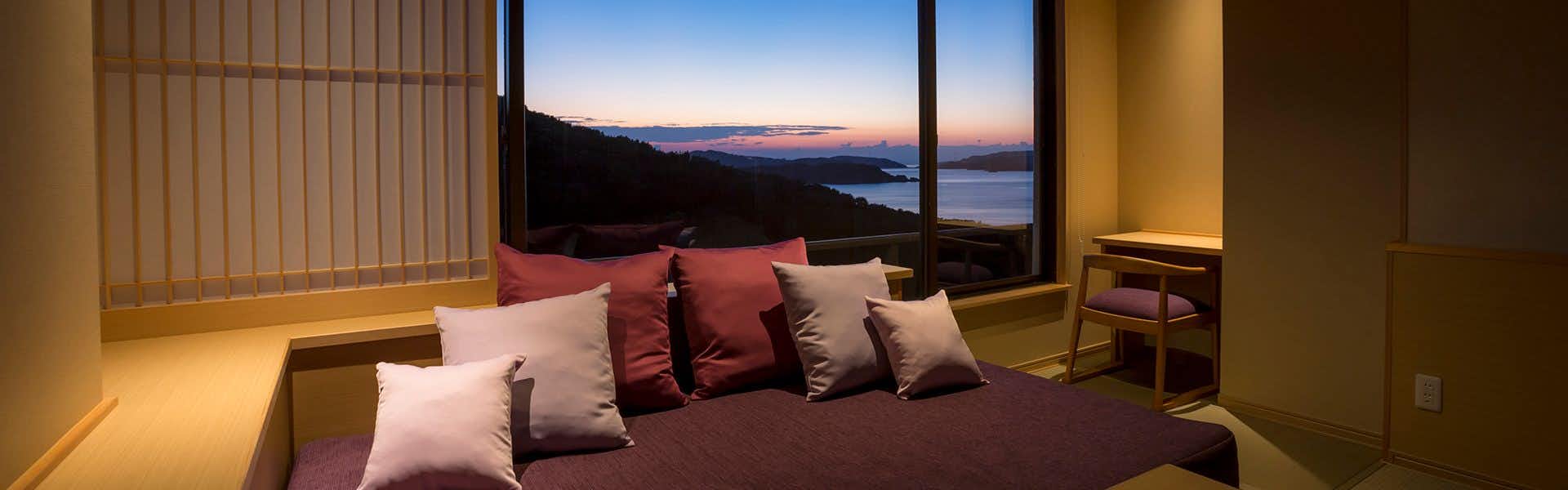 Inn of the Heart Bashinsui with a modern bedroom with purple bedding and sunset views.