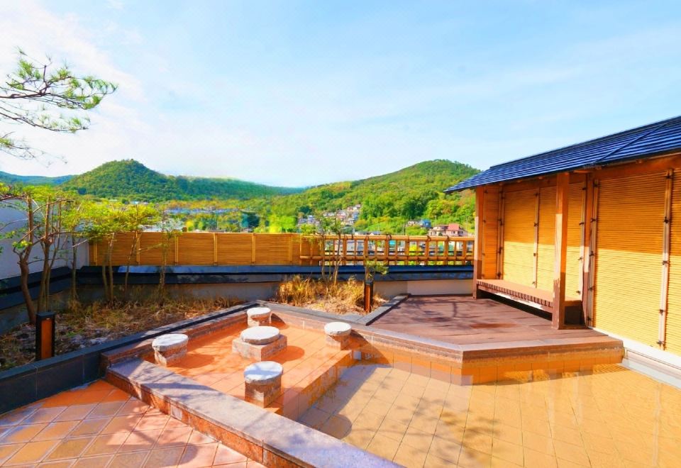 Open-air bath overlooking green hills.