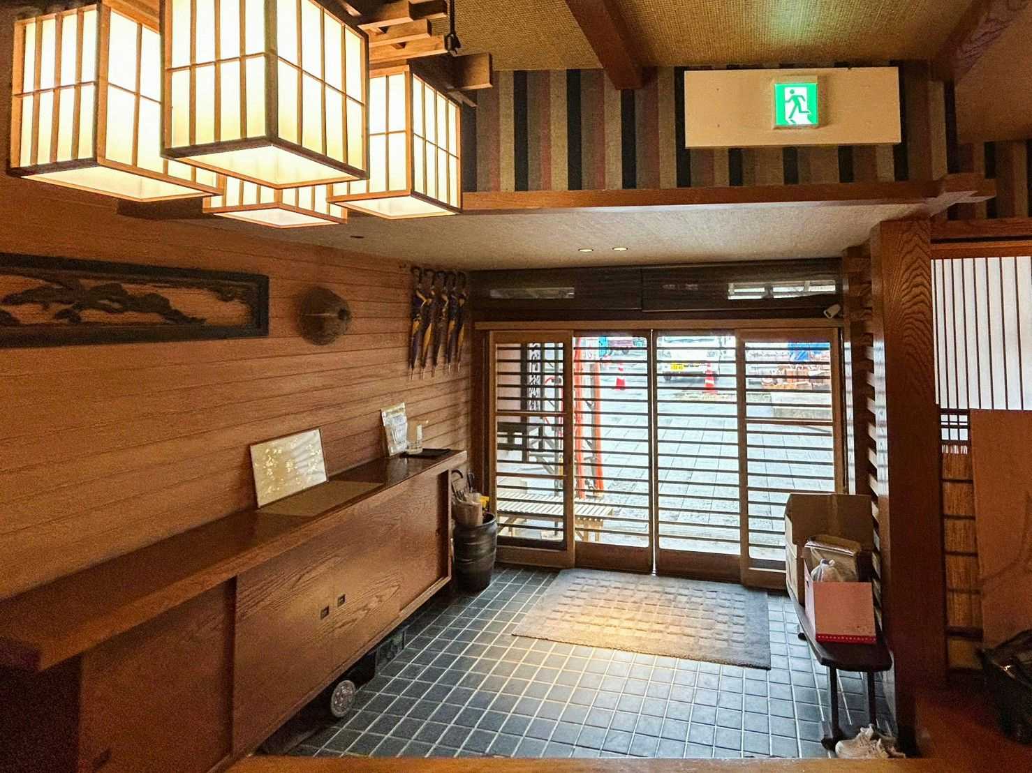 Sankai Ryokan with a warm timber foyer with lanterns and bench seating.